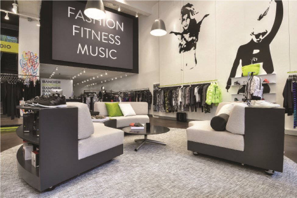 A modern interior view of the Bandier lifestyle and activewear boutique in Soho, built by MOMA Construction Group, featuring stylish lounge seating, architectural graphic wall art, and custom apparel display areas.