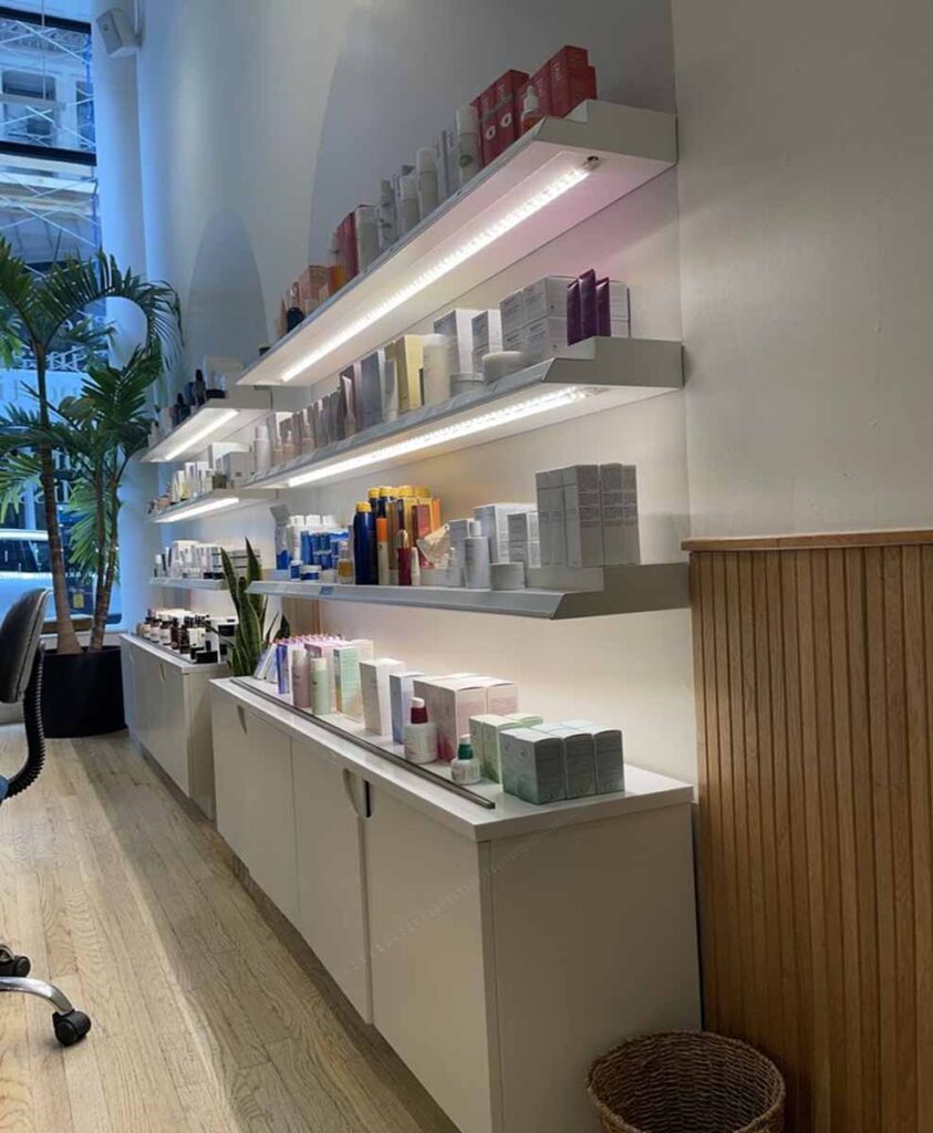 Medical spa product showroom on 19th Street with white base storage cabinets and natural vertical wood slot column partition.