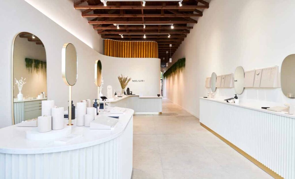 Upscale commercial retail showroom renovation by MOMA Construction Group showcasing a deep perspective of a modern jewelry boutique interior equpped with custom white ribbed display islands.