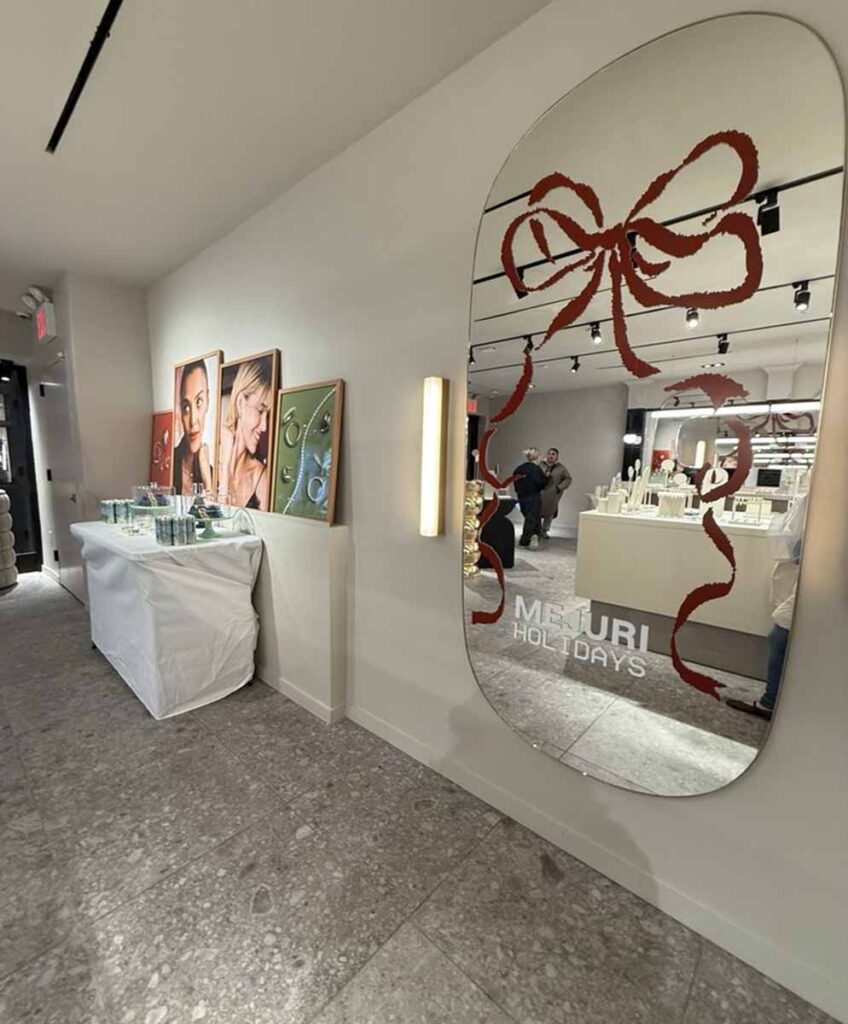 Commercial retail boutique interior fit-out by MOMA Construction Group in Williamsburg featuring a large custom bow-shaped decorative wall mirrow and displays for the Mejuri holiday poptup showroom.