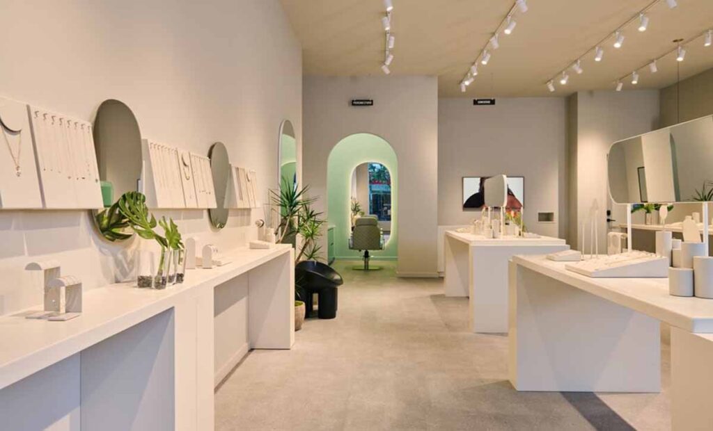 Commercial retail boutique interior fit-out by MOMA Construction Group in Glendale featuring a minimalist arched passageway with integrated lighting and extensive ceiling track lighting.
