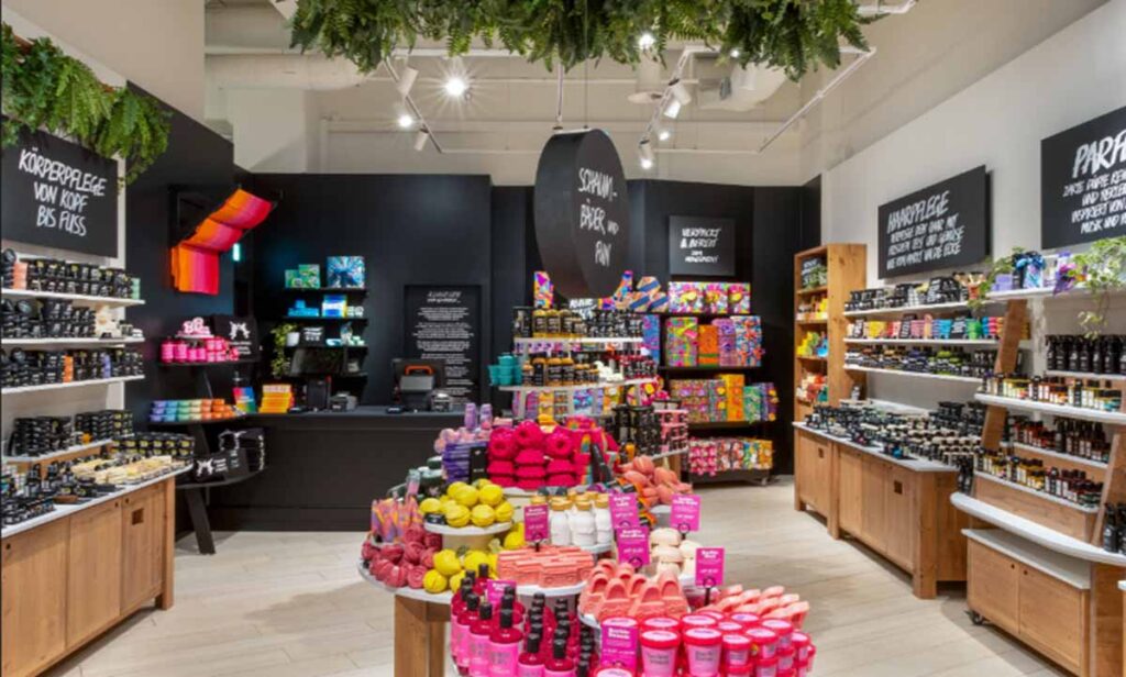 Commercial retail store interior renovation by MOMA Construction Group featuring an expansive cosmetics boutique layout with custom timber merchandising tables and white-faced display islands.